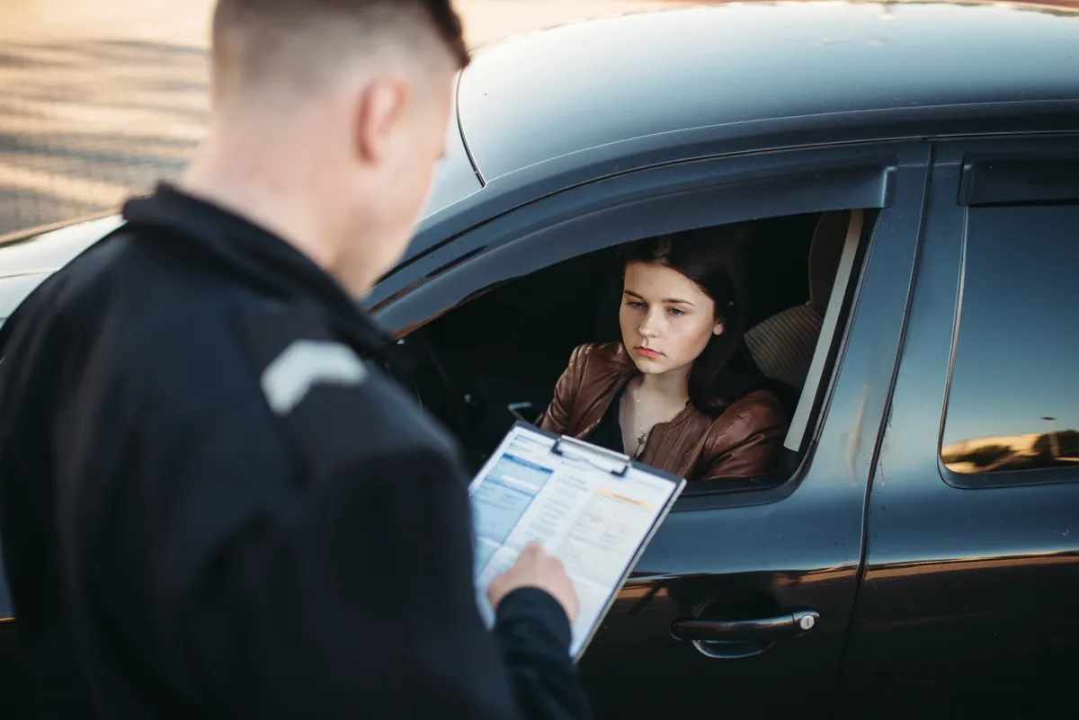 Professionnel &eacute;changeant avec une conductrice au sujet de son v&eacute;hicule